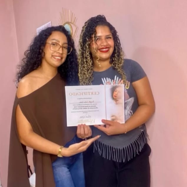 Aluna Kamylla com o certificado do curso, ao lado de Ericka Silva